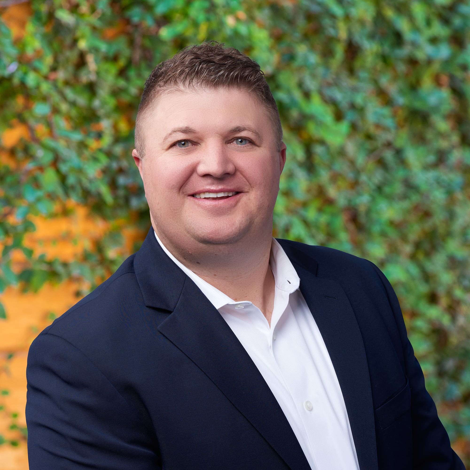 A man named Cody Phelan is smiling in front of a green wall.